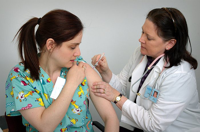 doctor give vaccination to woman patient